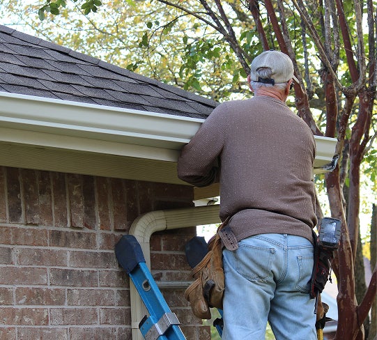 man on ladder fixing gutters, roofing winston salem, roof repair greensboro, roofing company high point, roof repair mount airy