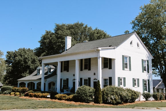 white residential house showcasing the best shingles for roofs